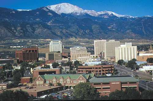 A large building with a mountain in the backgroundDescription automatically generated